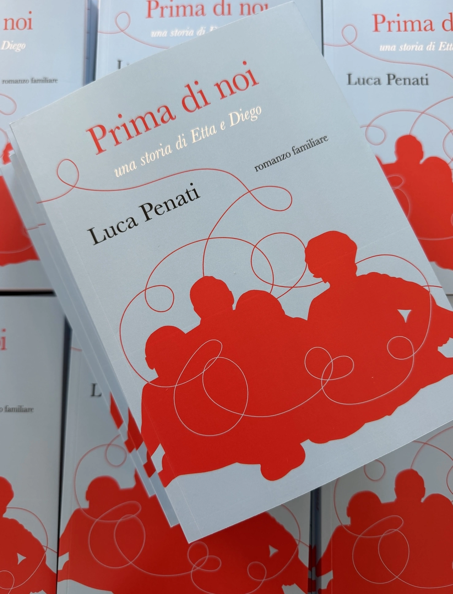 Alcune copie stampate di Prima di noi impilate su un tavolo